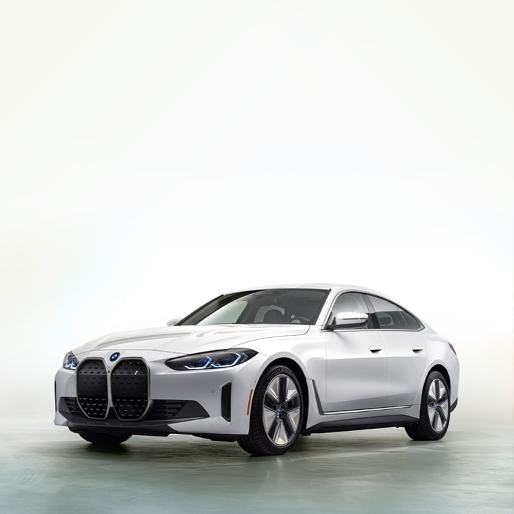 An all-electric BMW i4 Gran Coupe parked against a white background