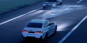 Image of a BMW driving during the night with high beam usage