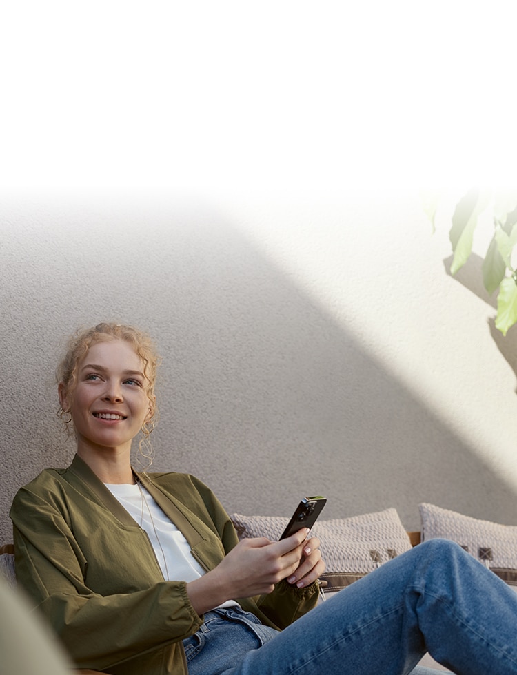 A BMW sedan drives past an idyllic forested meadow.