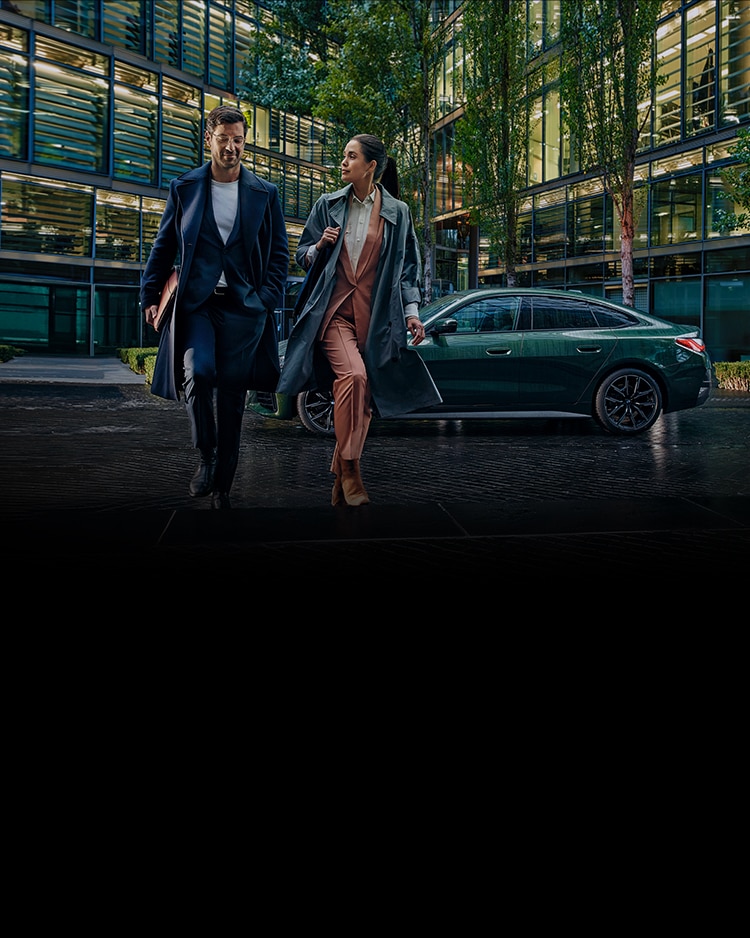 A couple walks away from their BMW in a city setting