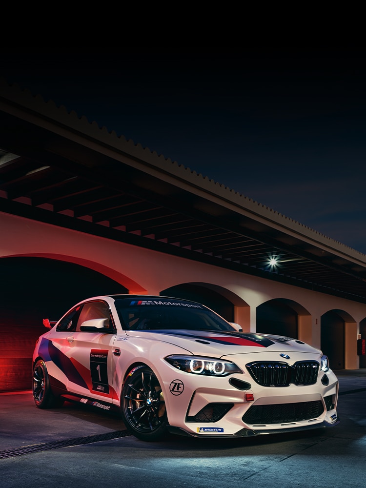 A BMW M2 CS Racing parked outside a garage