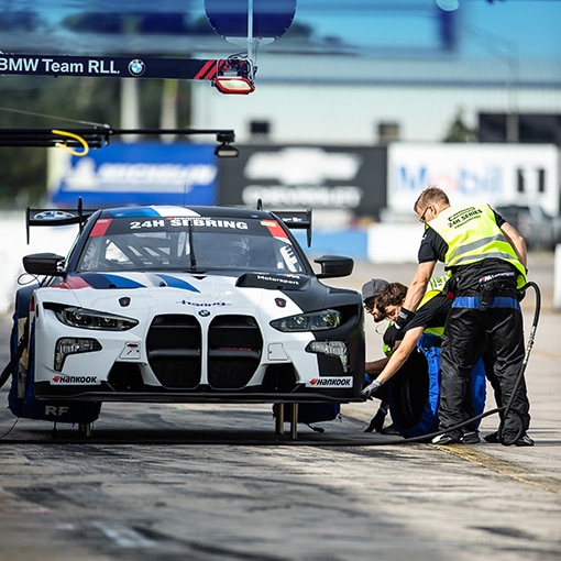 A BMW M4 GT3 being serviced by the pit crew