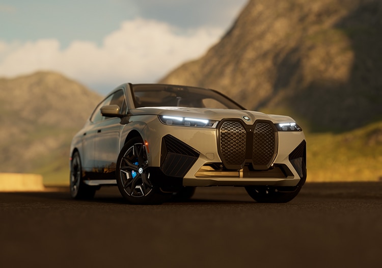Front three-quarters image of a 2025 BMW iX with slim twin headlights on and blurred mountains in the background.