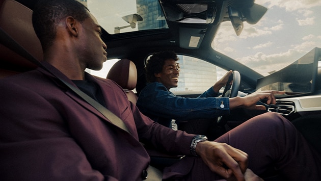 A driver and passenger enjoying their drive with the latest BMW software