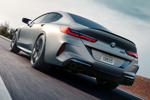 A 2025 BMW M8 Competition Gran Coupe showing taillights and quad exhaust