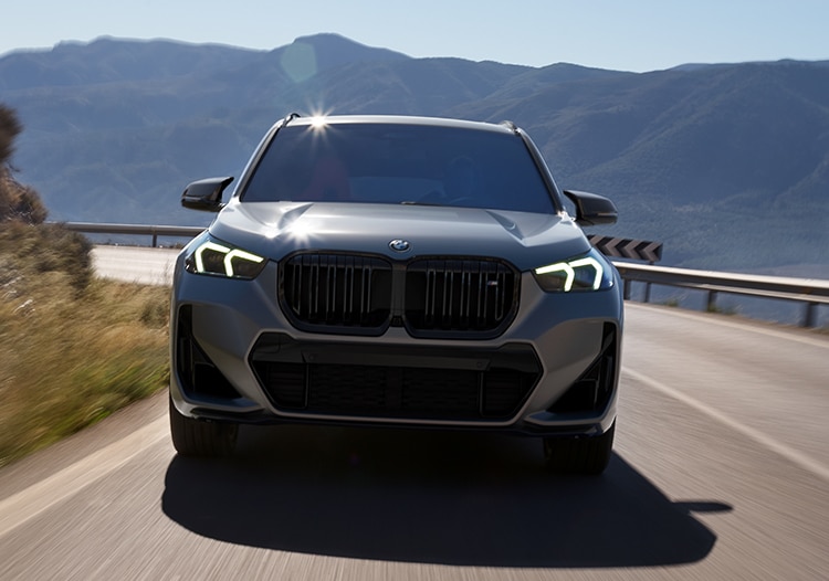 Dramatic front view of the X1 driving down a picturesque highway.