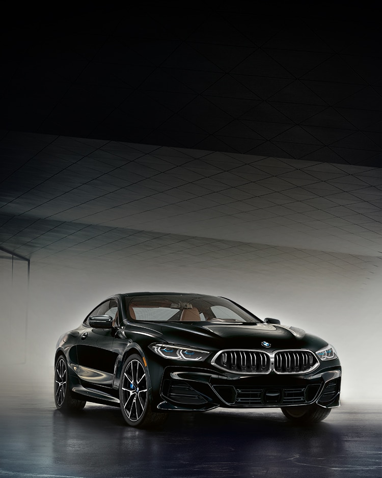 The 2026 BMW 840i Coupe dramatically lit in a modern garage 