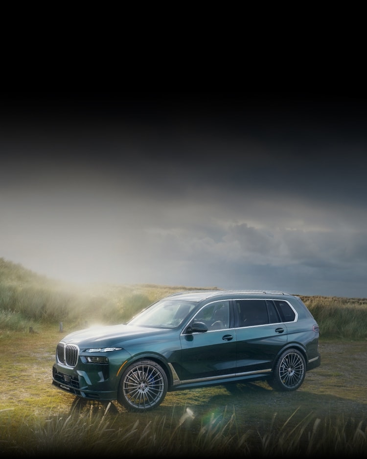 The 2026 ALPINA XB7 in Green Metallic paint parked in a field of waving grass