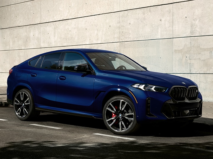 Profile view of the 2026 BMW X6 parked on a city street