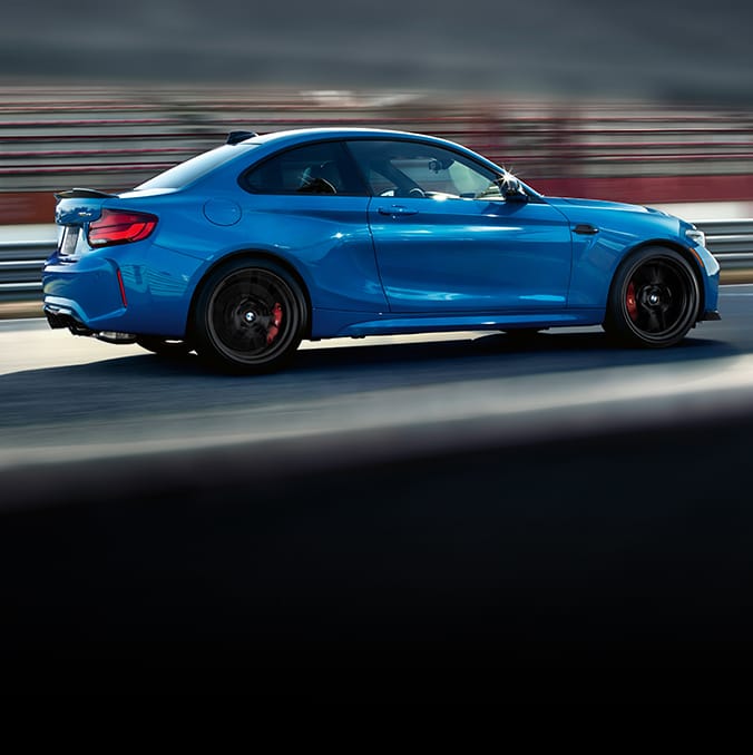 Side profile of Limited Edition BMW M2 CS driving on racetrack with blurred background