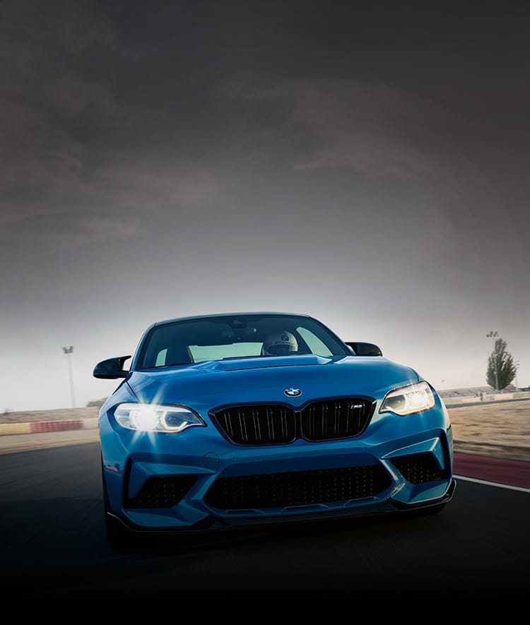 Front profile of the Limited Edition BMW M2 CS in Misano Blue Metallic driving on racetrack