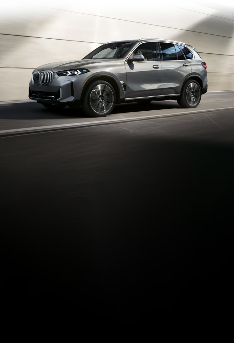 Dynamic shot of the BMW X5 driving in an slick urban setting