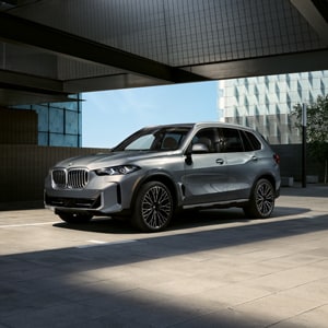 A BMW X5 parked in a urban garage on a sunny day